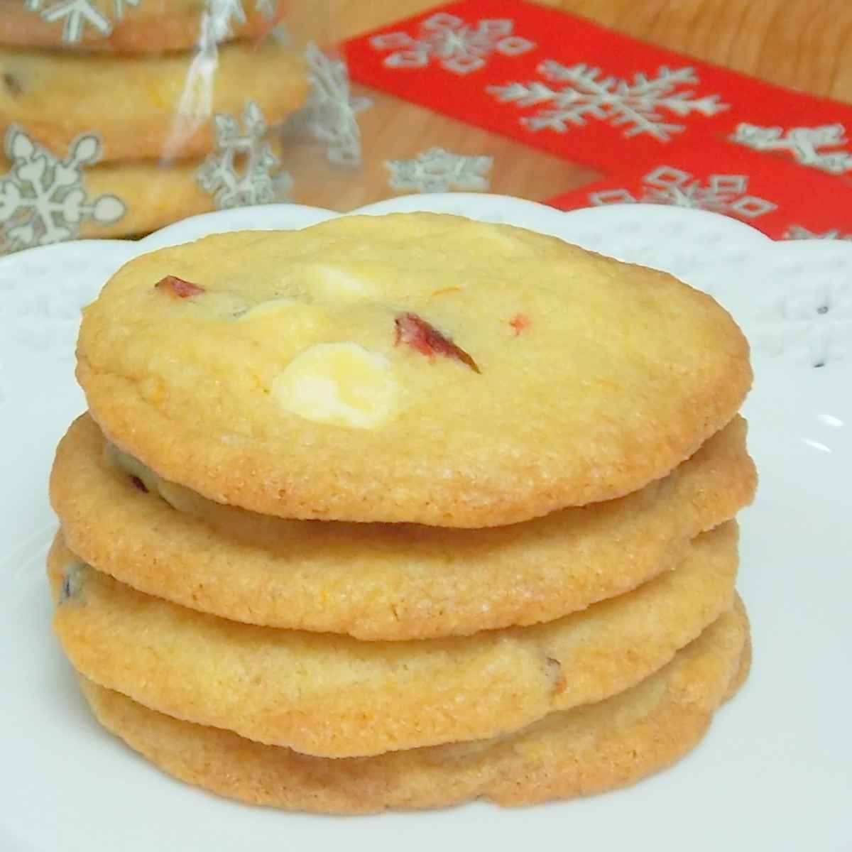 A stack of 4 White Chocolate Cranberry Cookies on a white plate.