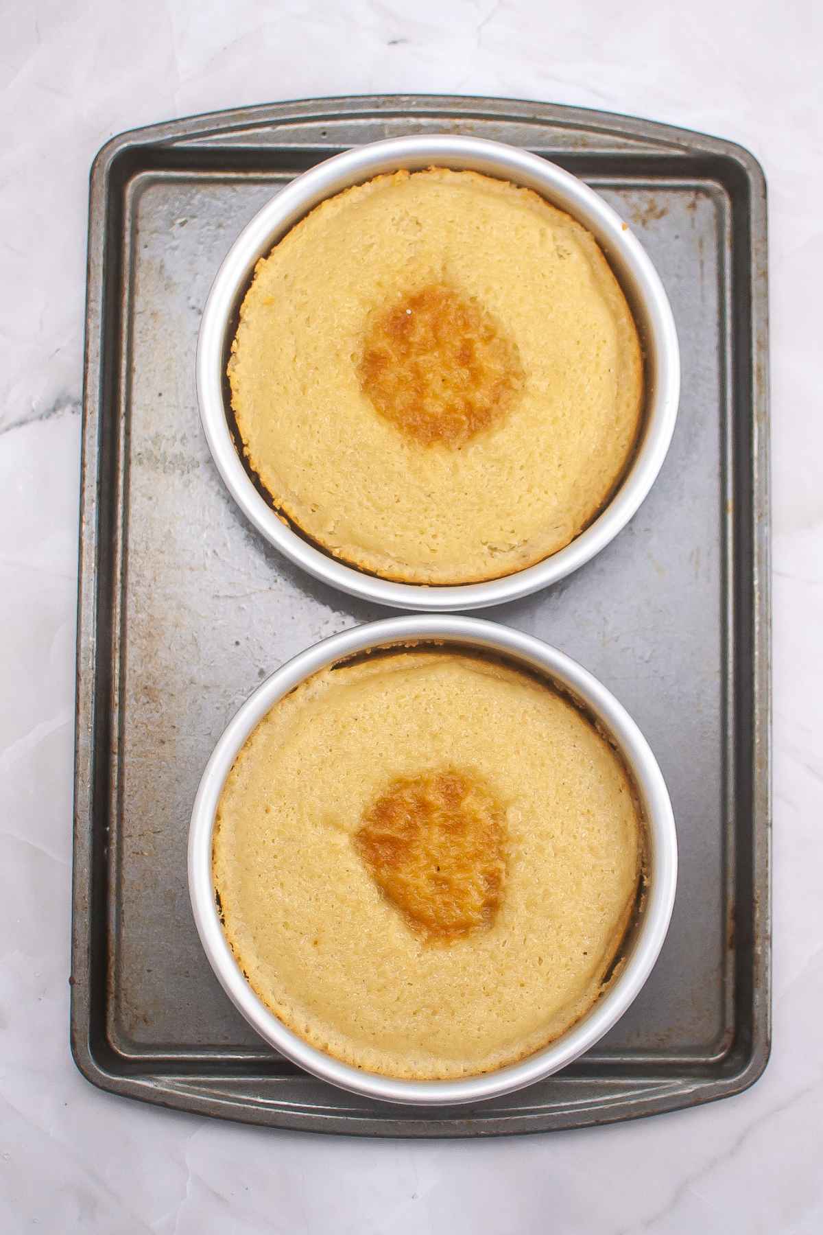 Two baked cakes on a baking sheet.