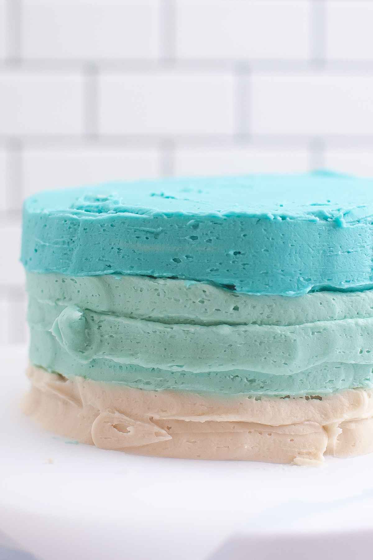 Layer cake with light blue, dark blue, and white frosting layers piped onto the sides of the cake.