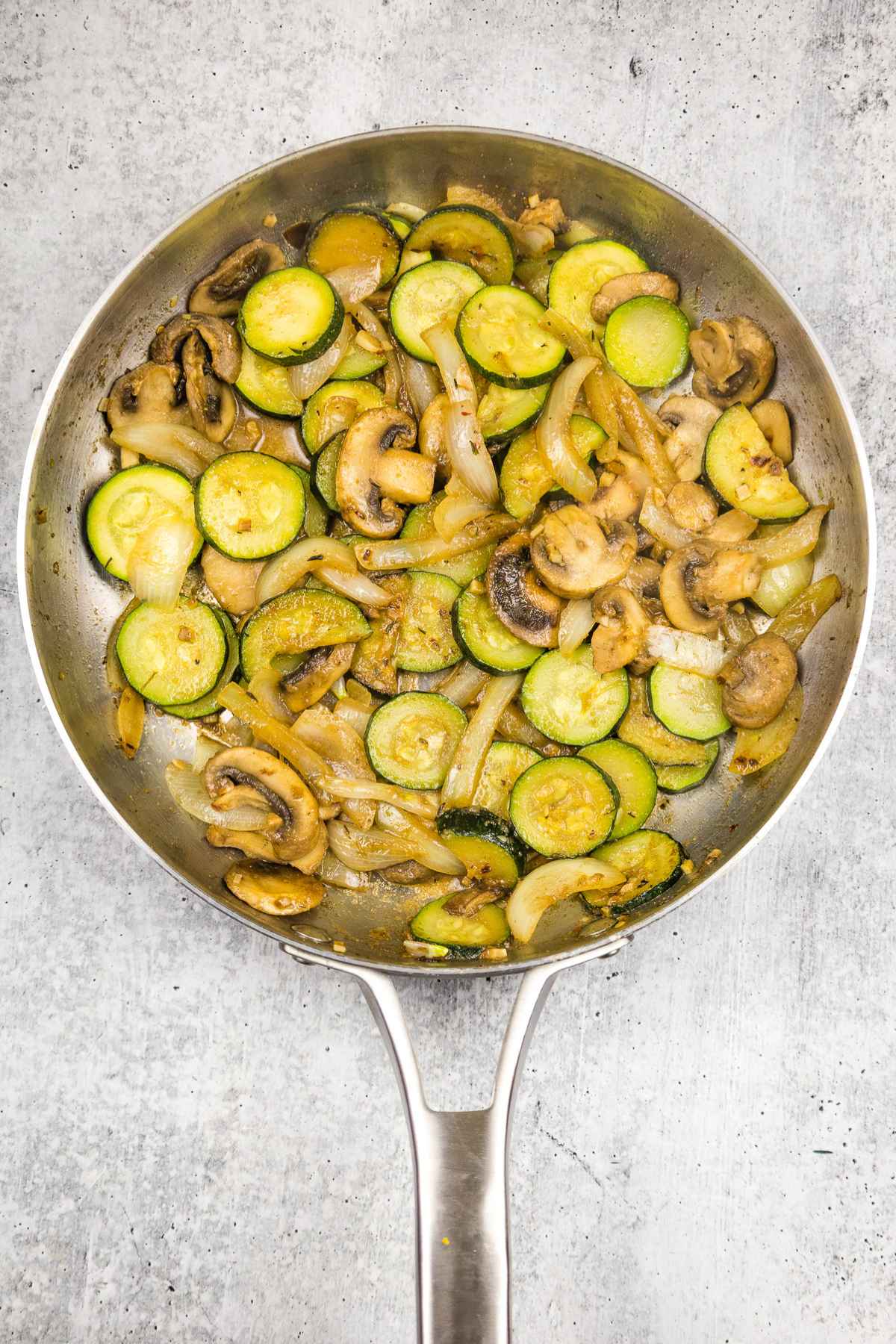 Sauteed zucchini and mushrooms in a skillet.