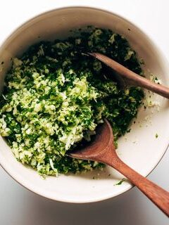 Pulse-chopping cabbage and kale in batches inside a food processor bowl